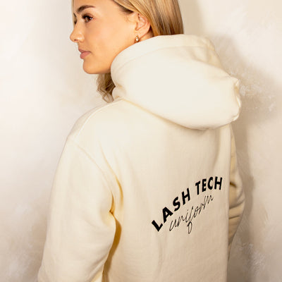 Beiger Hoodie mit der Aufschrift 'Lash Tech Uniform'.